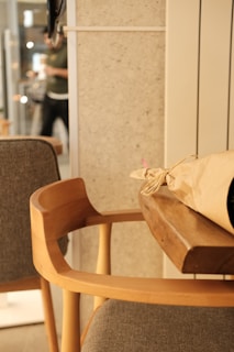 A cozy wooden chair beside a small table with a vase of fresh flowers, reflecting the warmth of hsb interior's furniture.