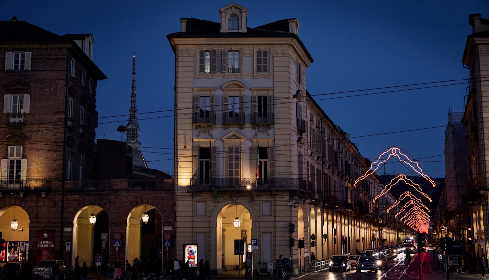 una calle de la ciudad por la noche con un edificio iluminado