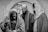 Three men are depicted in a dramatic black and white setting, dressed in historical or biblical clothing. The man in the foreground has a long beard and appears weary or introspective, leaning on a staff. The two men in the background are looking in different directions, with expressions that convey seriousness or contemplation.