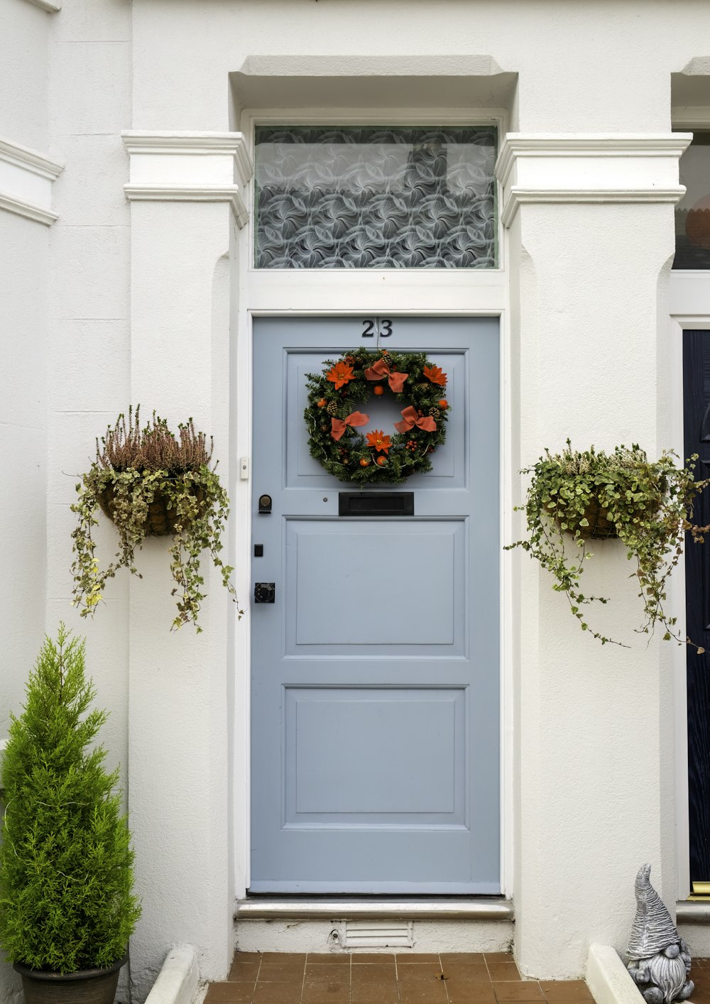 uma porta da frente azul com uma coroa de flores