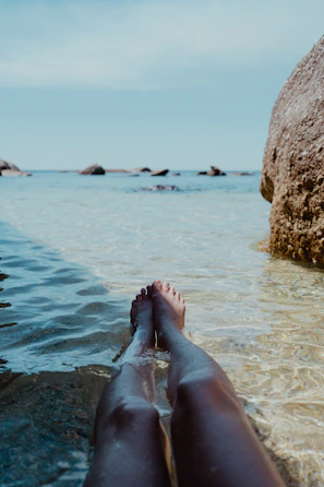 a person's feet sticking out of the water