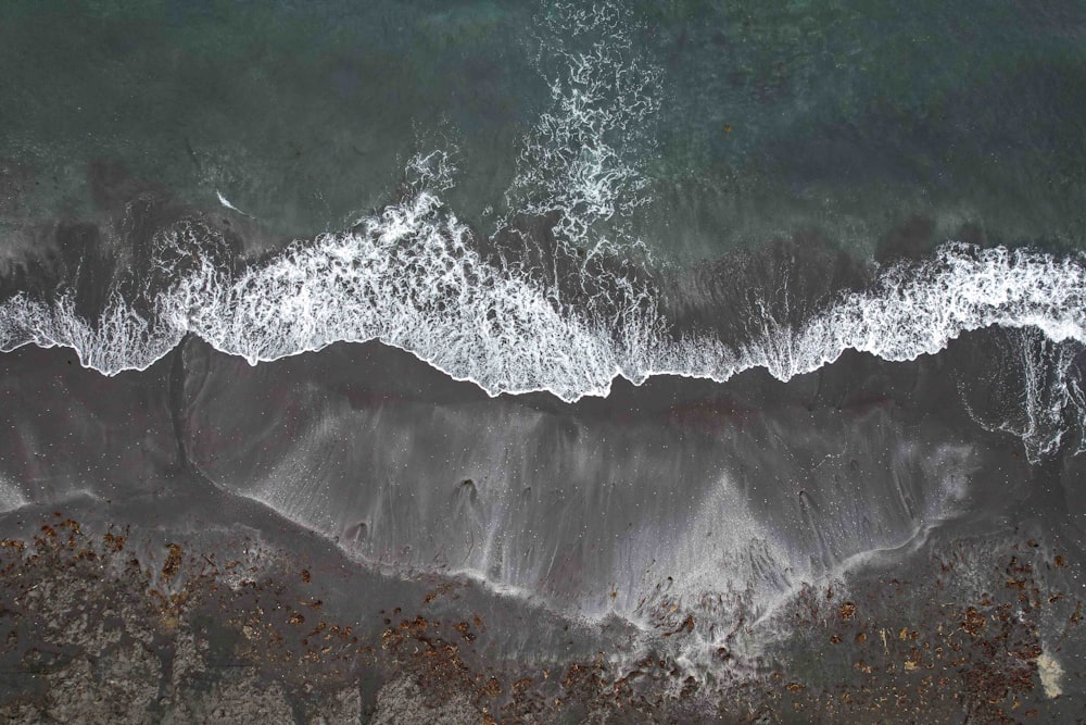 an aerial view of a beach with waves crashing on it