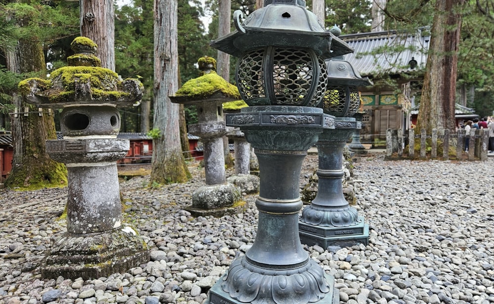 Un grupo de linternas de piedra sentadas en la parte superior de un campo de grava