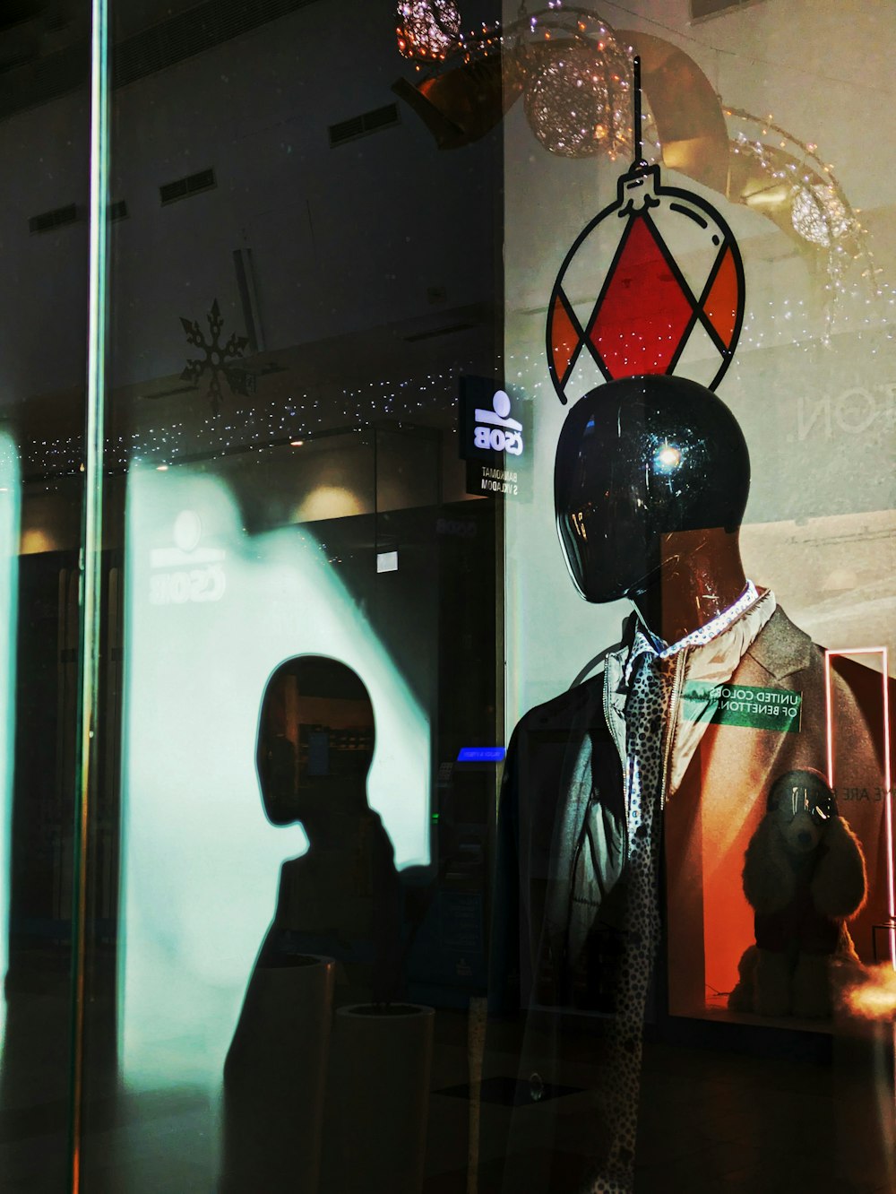 a mannequin wearing a suit and tie in front of a window
