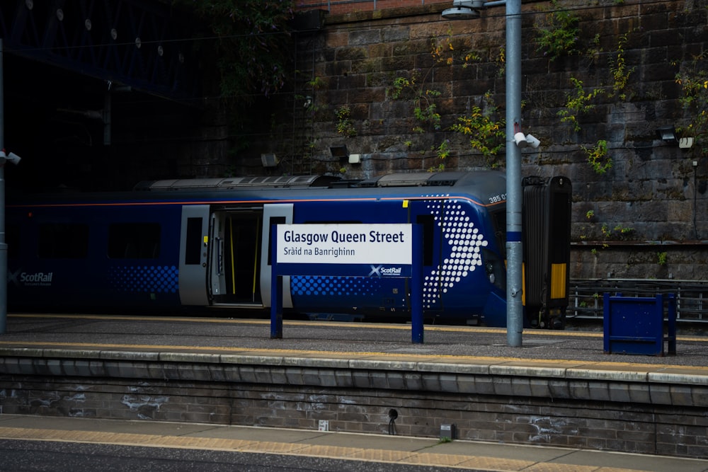 a blue train parked at a train station