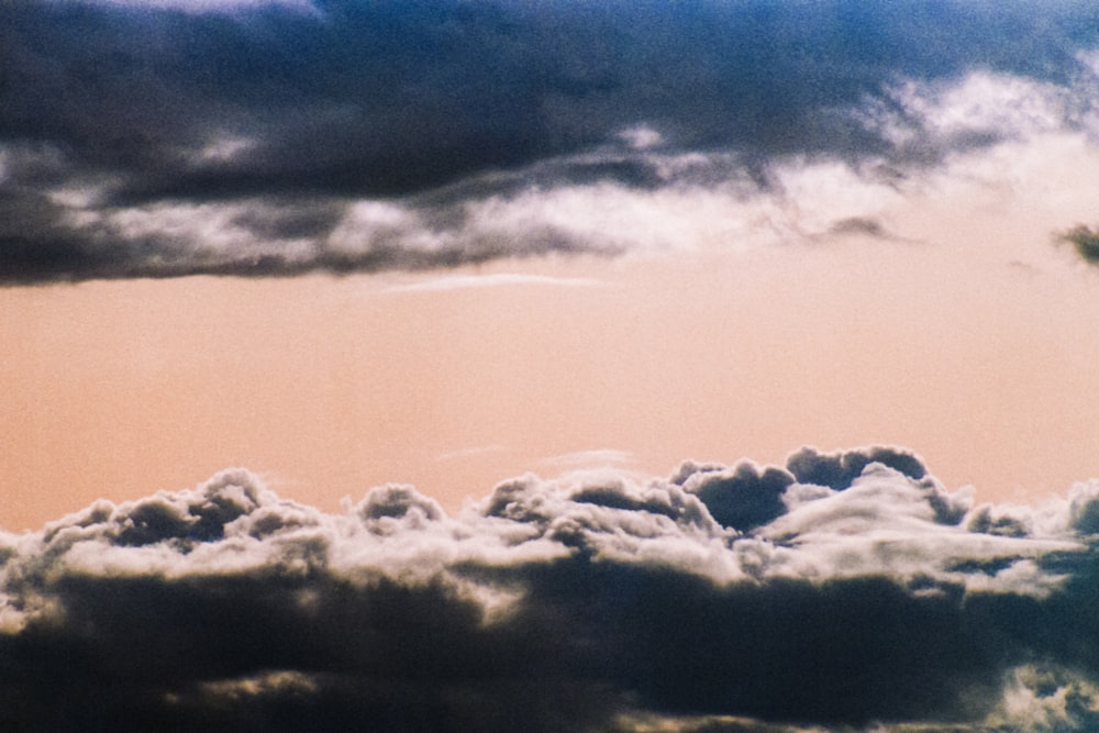 a plane flying in the sky with a lot of clouds