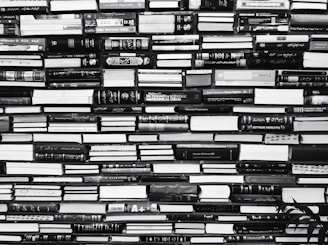 a black and white photo of books stacked on top of each other