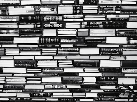 a black and white photo of books stacked on top of each other