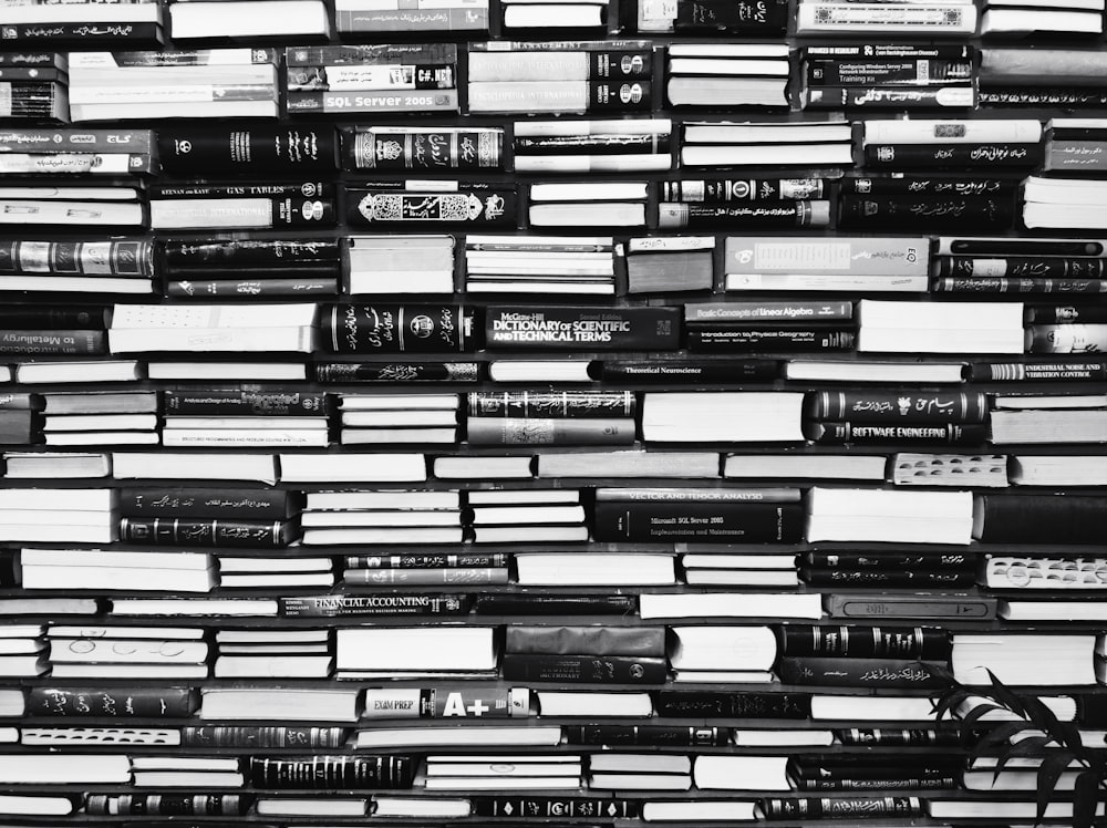 a black and white photo of books stacked on top of each other