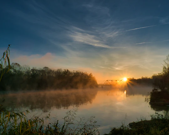 A serene sunrise over a peaceful river symbolizing God's providence.