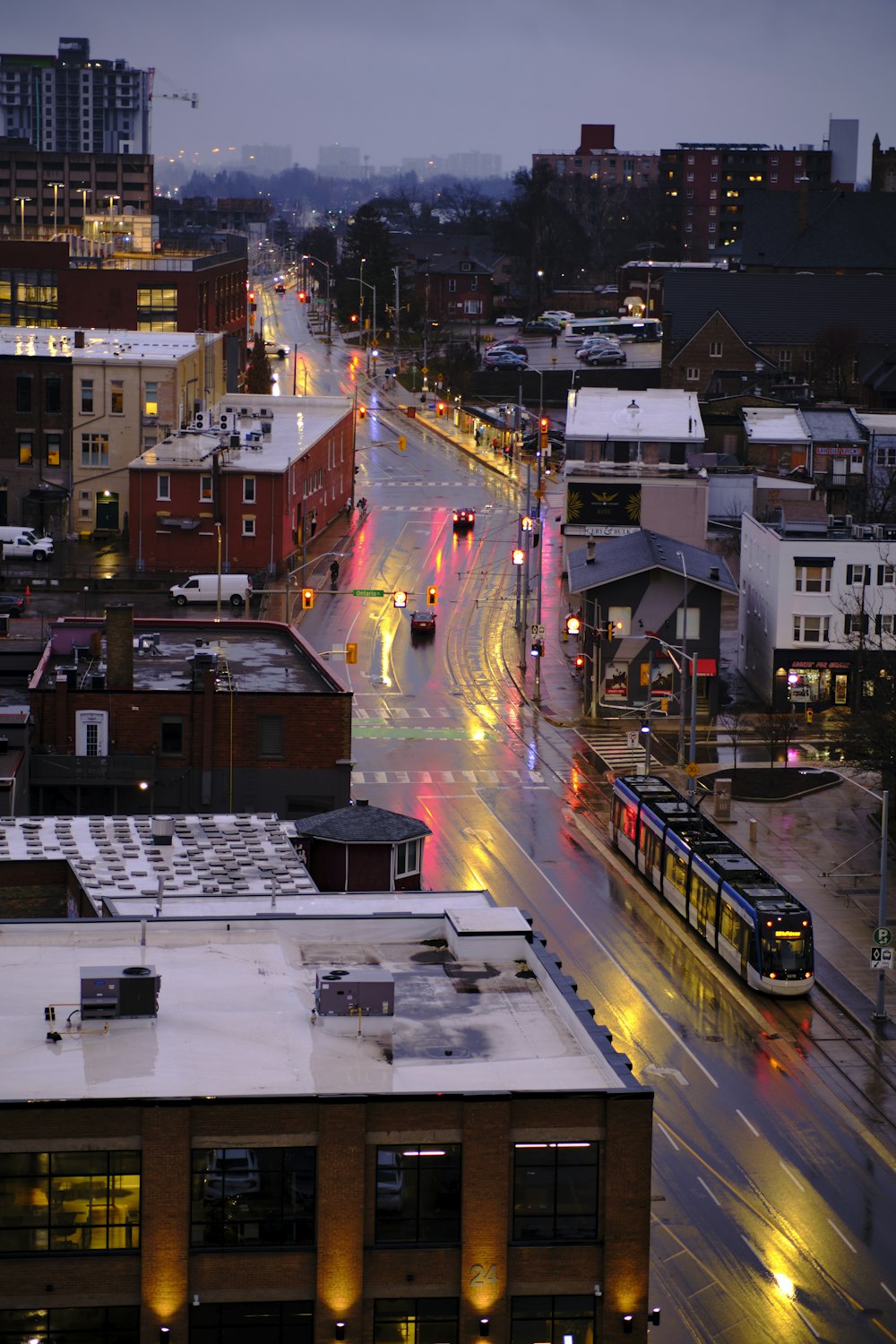 a city street at night with a train on the tracks