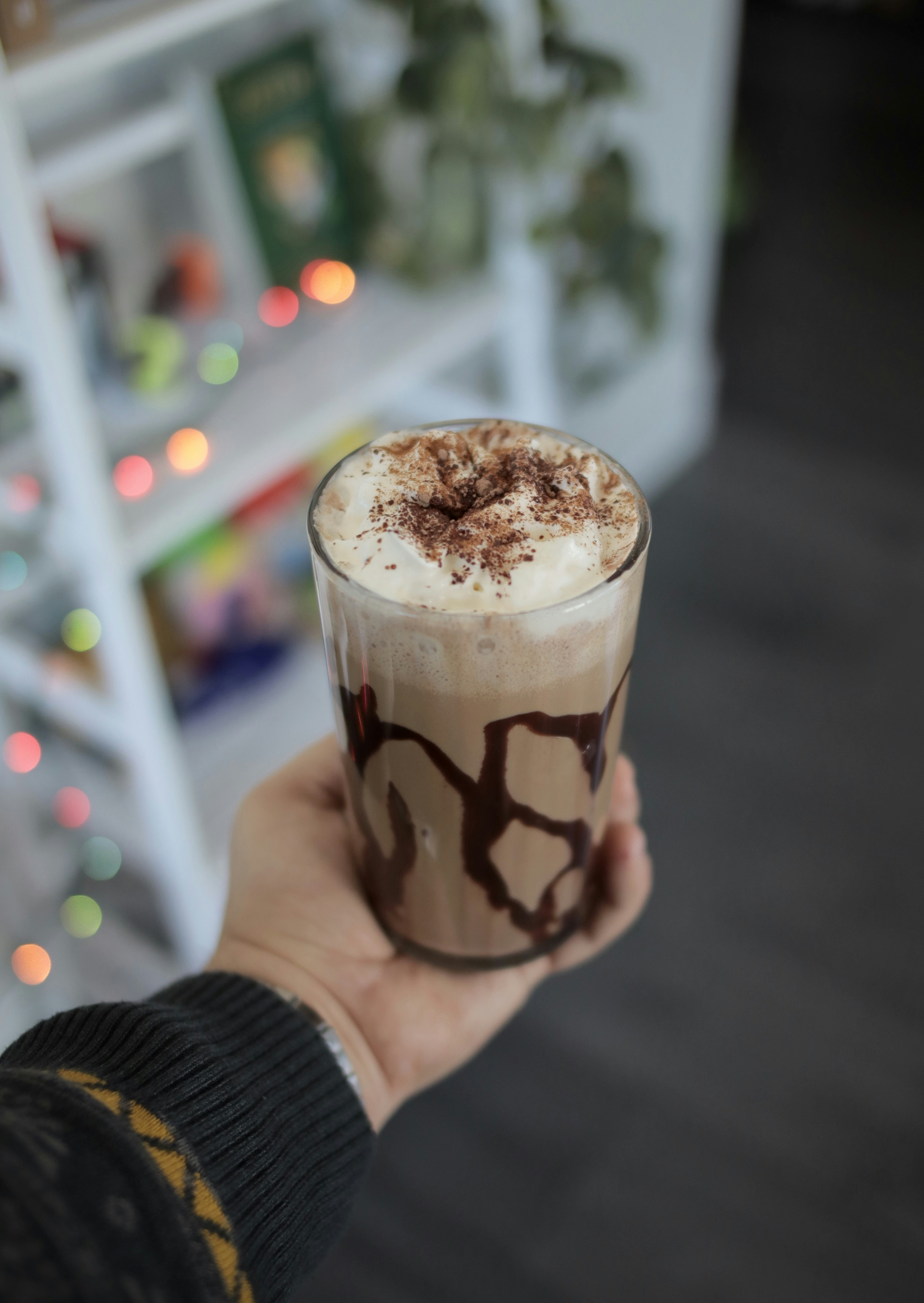Thick creamy chocolate milkshake in tall glass with whipped cream