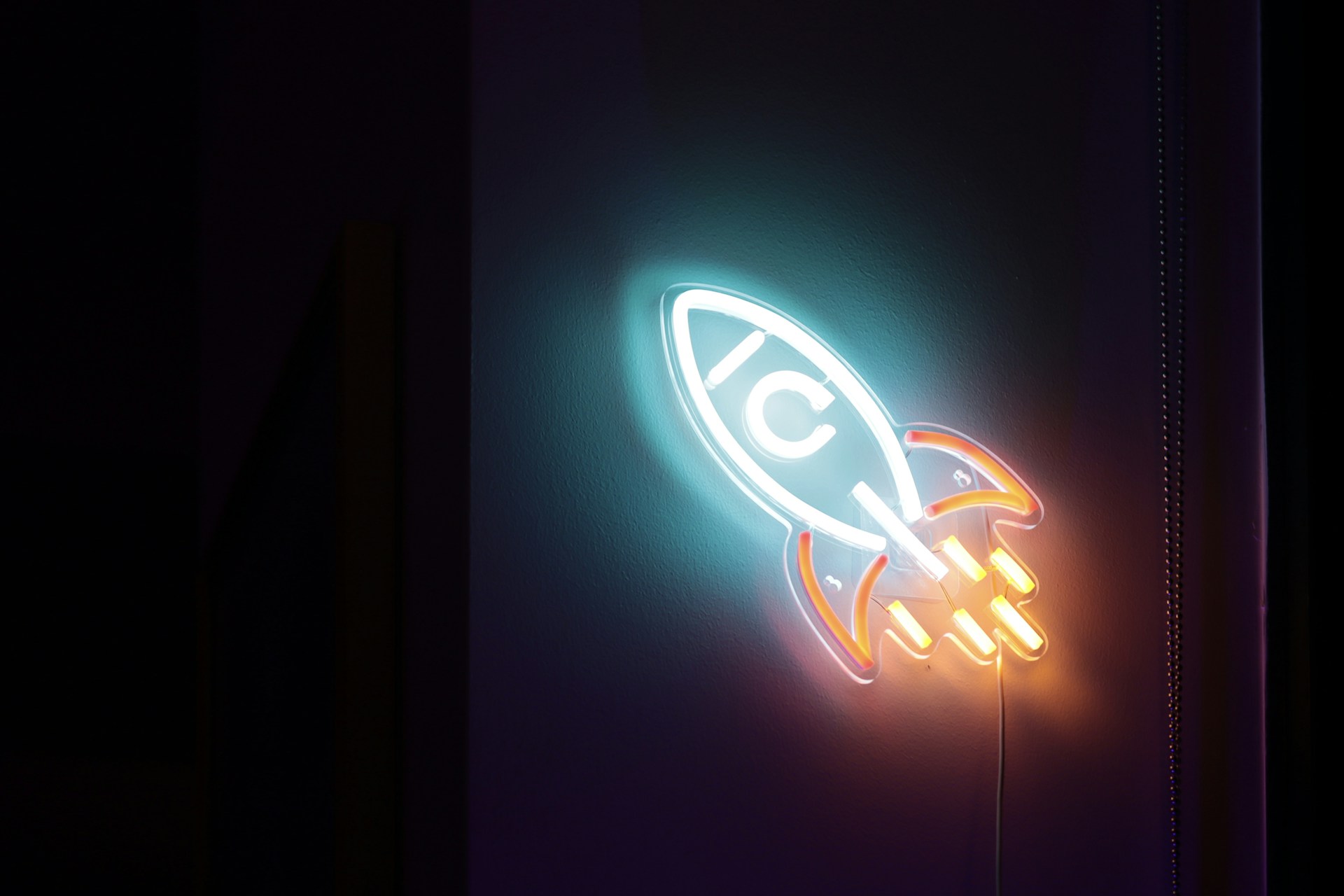 a neon sign with a rocket ship on it