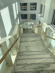 Marble staircase with sleek handrails and natural light.