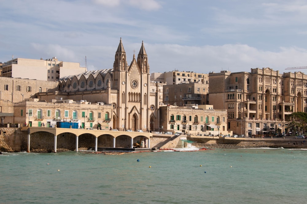 a large building with a clock tower next to a body of water