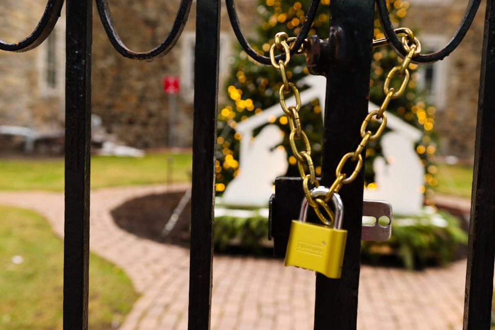 a yellow padlock attached to a black gate