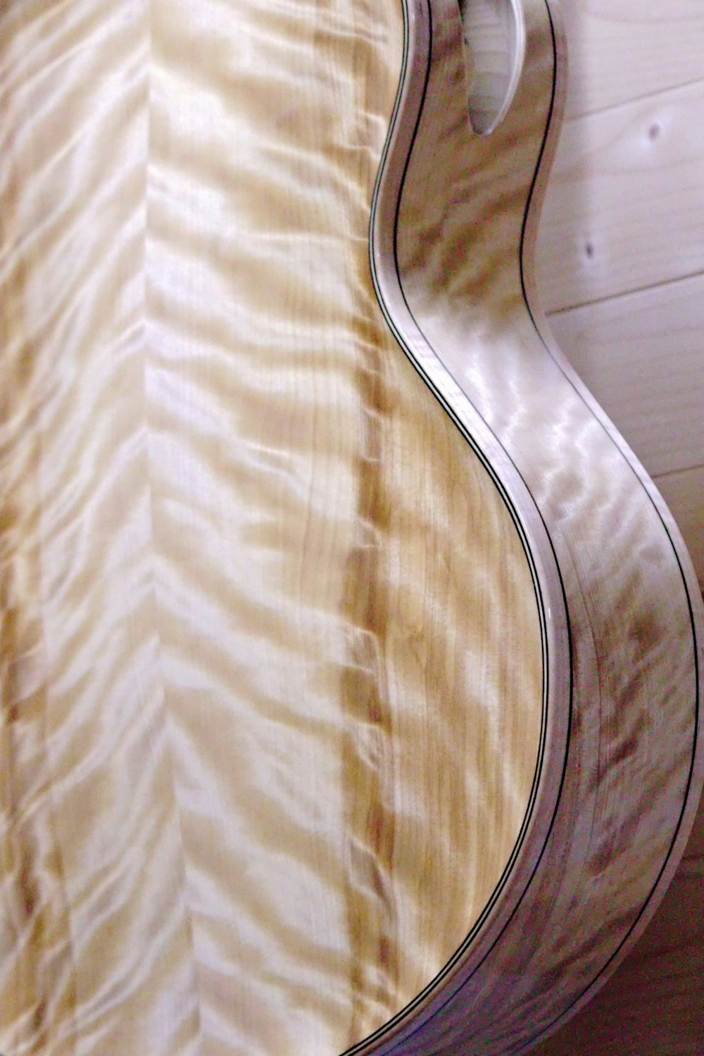 Un primer plano de un mástil de guitarra en una pared
