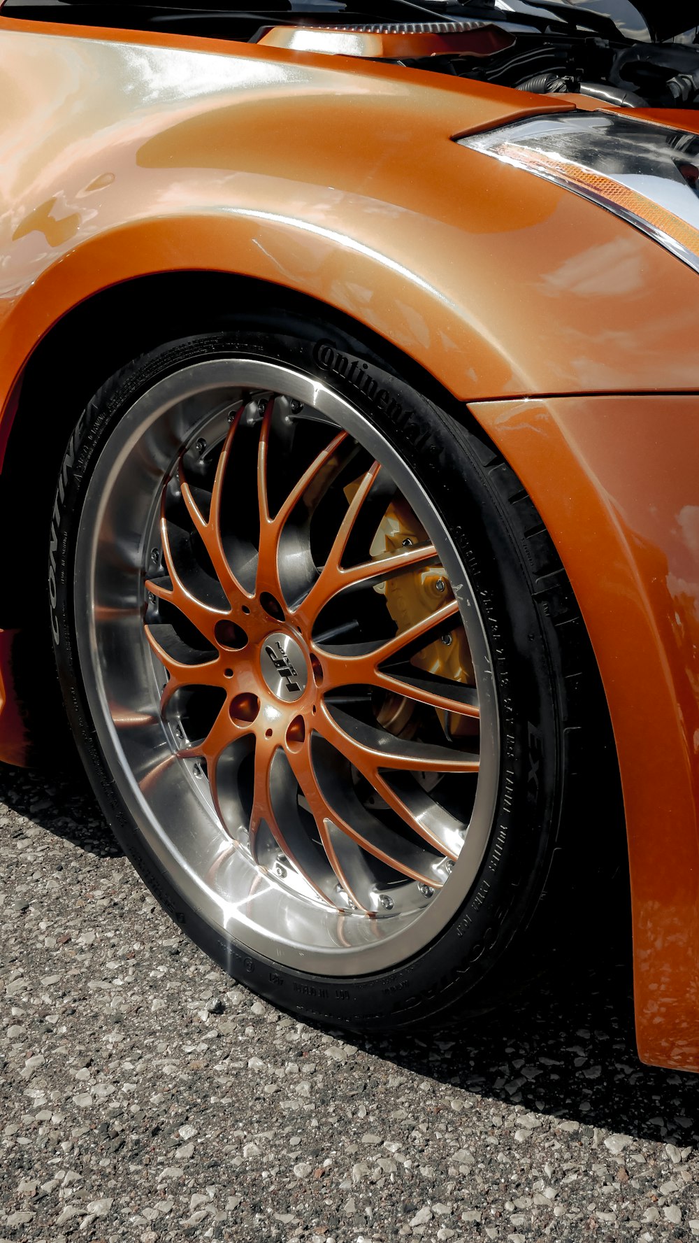 a close up of a orange sports car tire