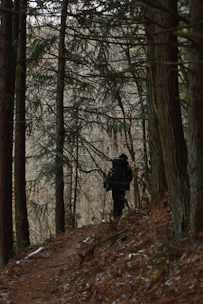 Close-up of a hiker wearing a sleek hypershell exoskeleton on a forest trail.