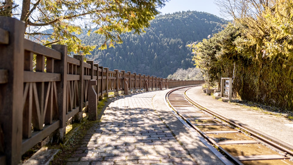 a train track next to a wooden fence