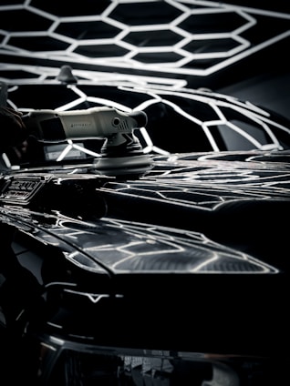 Close-up of a car being professionally detailed with polishing tools