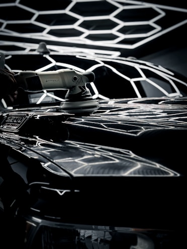 Tools and materials arranged neatly for polishing a car surface.