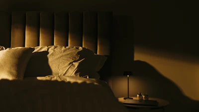 A cozy, softly lit bedroom corner with elegant sensual accessories displayed.