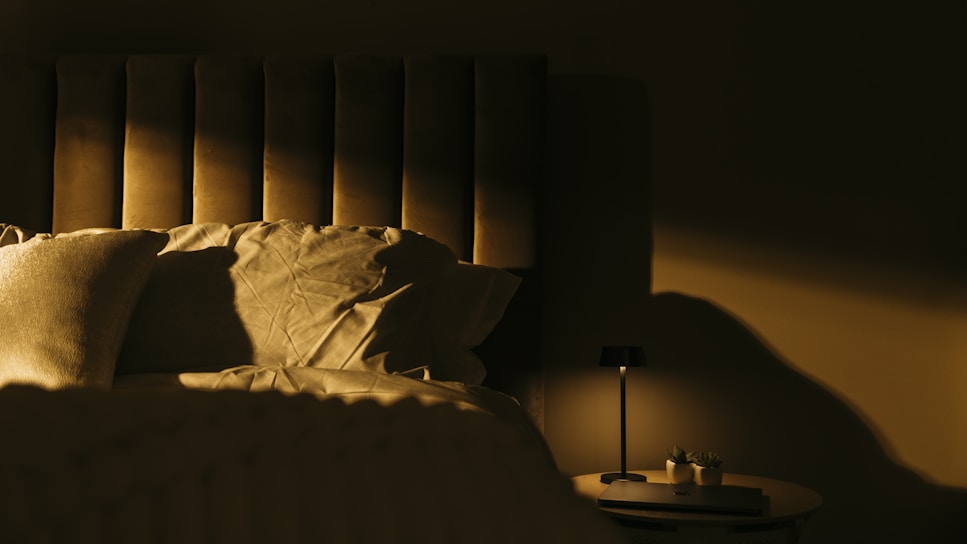 A peaceful bedroom with soft lighting and a dream journal on the bedside table.