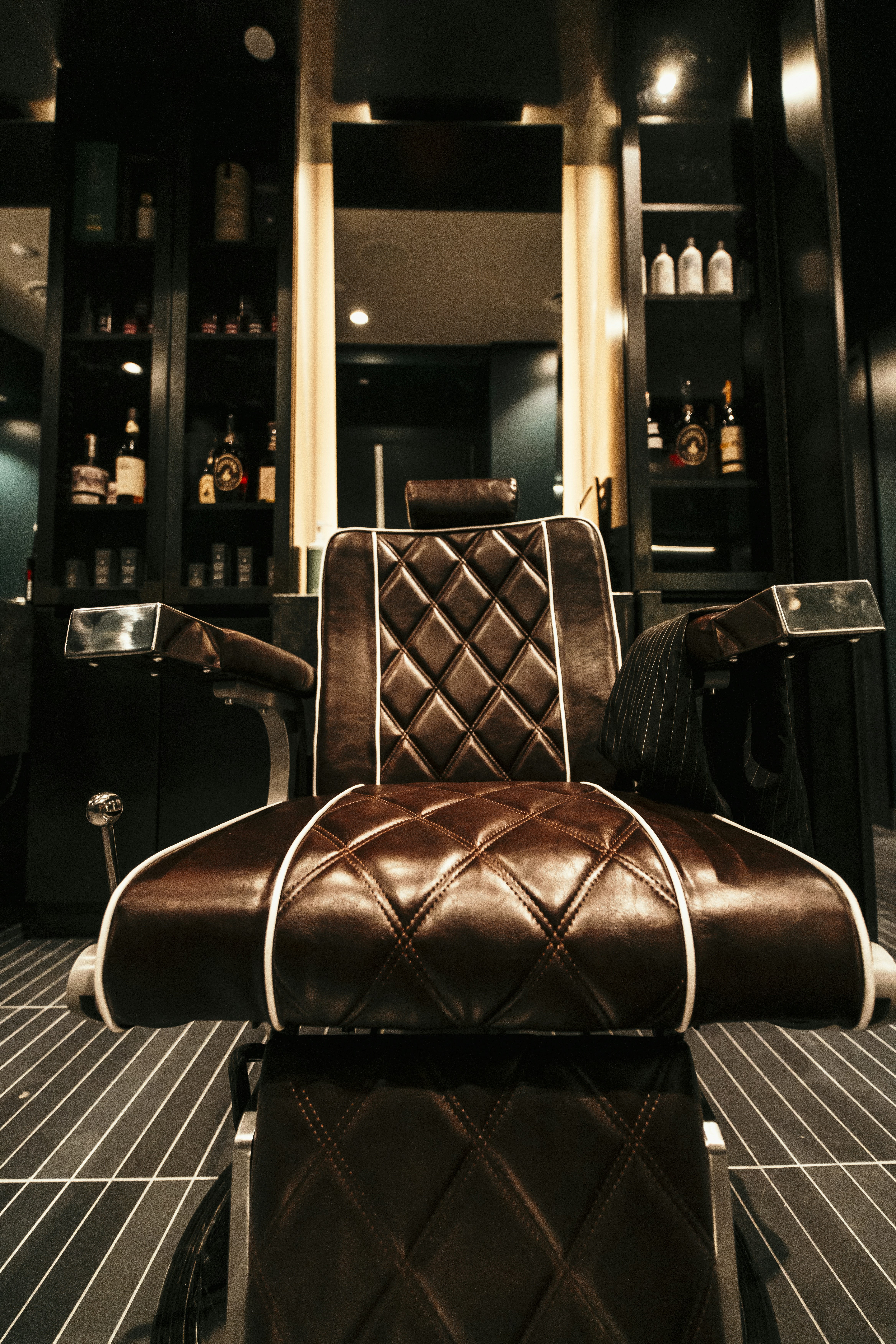a brown leather chair sitting in front of a mirror