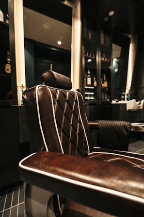Elegant salon interior with black and gold accents, showcasing a luxurious styling chair.