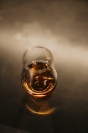 Close-up of a vintage whisky bottle with golden amber liquid glowing under soft light.