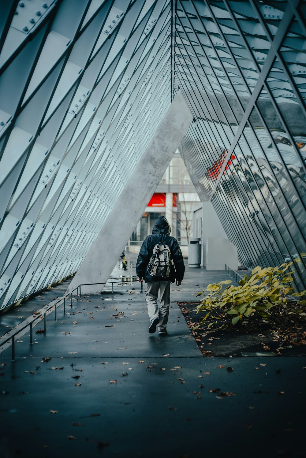 a man walking down a walkway in front of a building