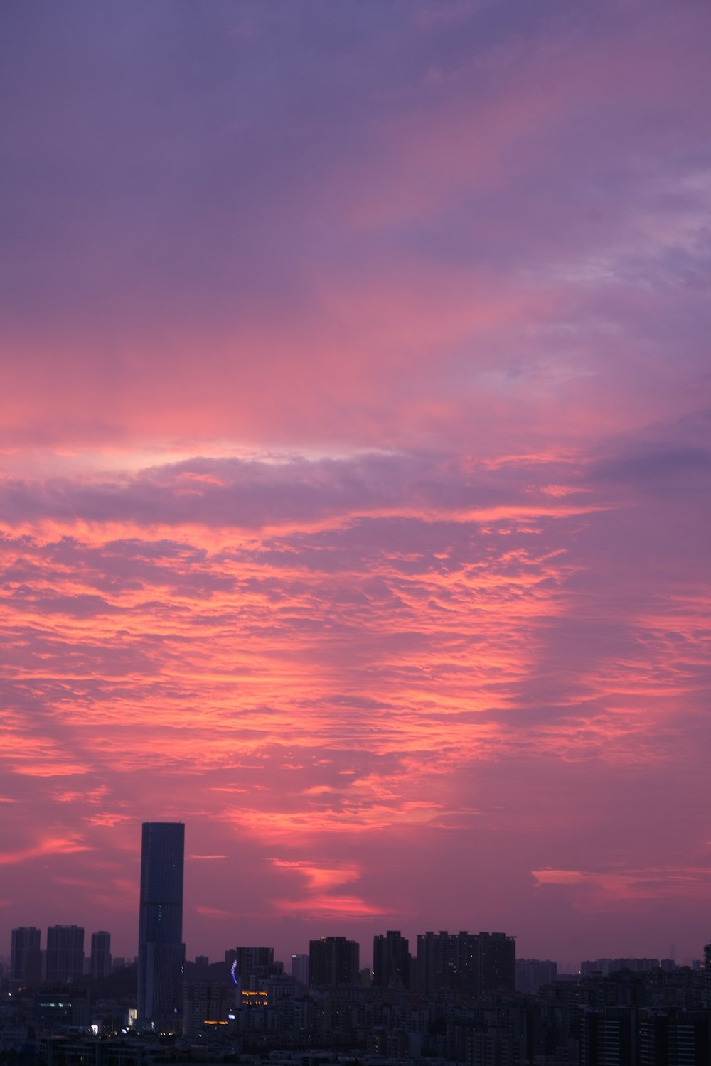 a sunset view of a city with tall buildings