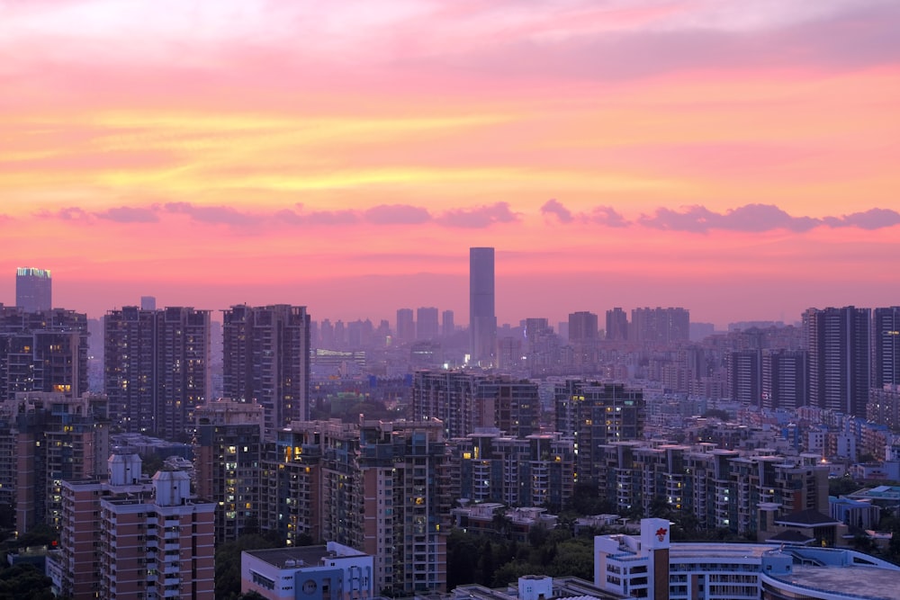 a view of a city with tall buildings at sunset