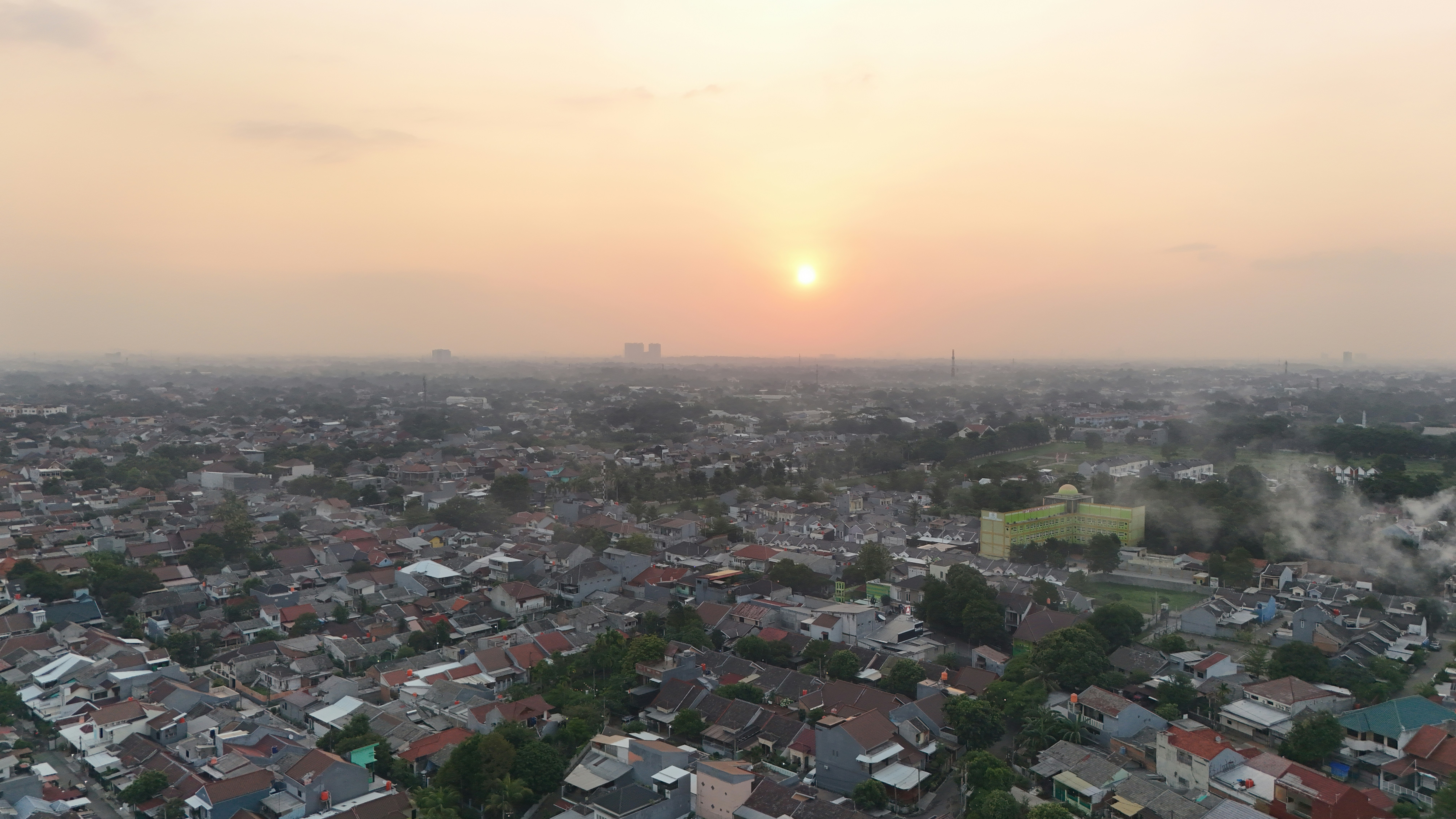 the sun is setting over a cityscape