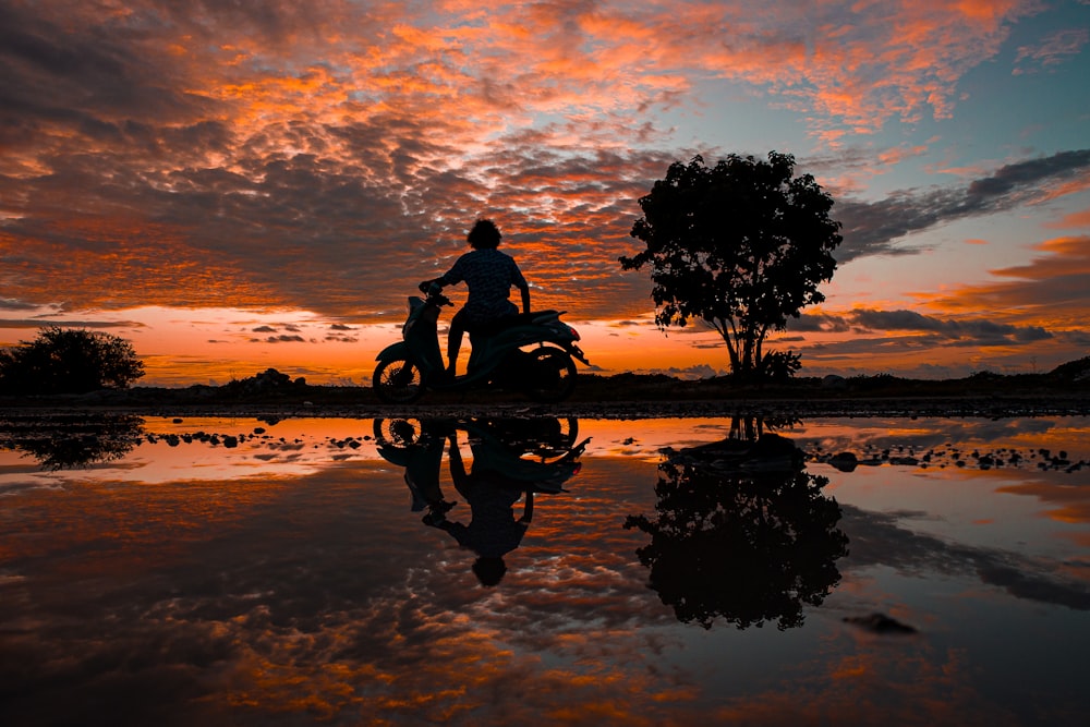 Ein Mann fährt auf einem Motorrad auf einem See
