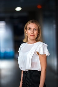 a woman in a white top and black pants