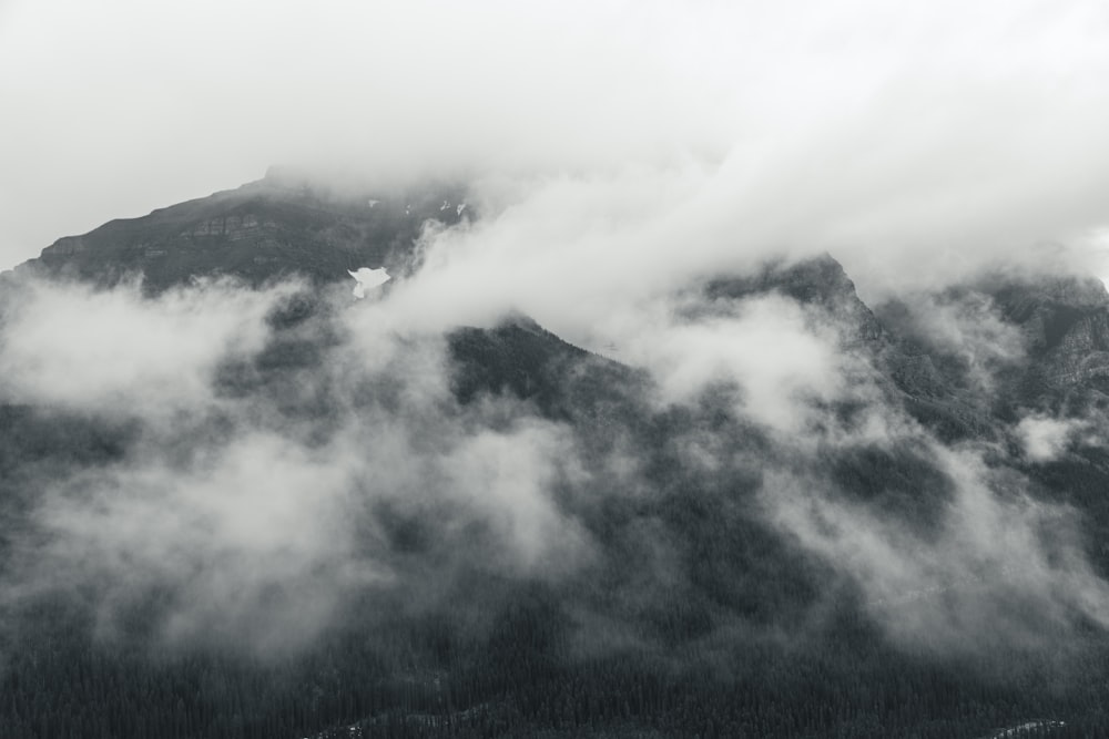 Ein Schwarz-Weiß-Foto eines wolkenverhangenen Berges