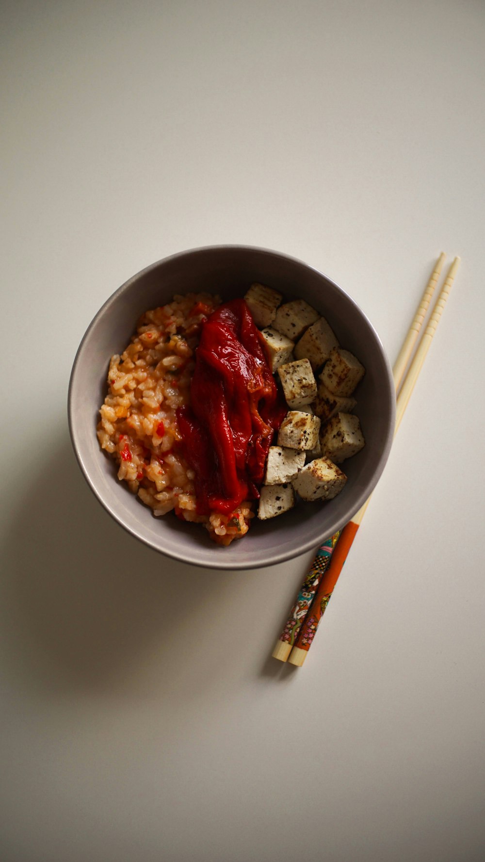 a bowl of food and chopsticks on a table