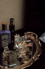 Elegant perfume bottles arranged on a traditional Middle Eastern wooden tray with intricate patterns.