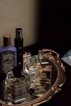 Elegant perfume bottles arranged on a wooden tray surrounded by oud wood chips.