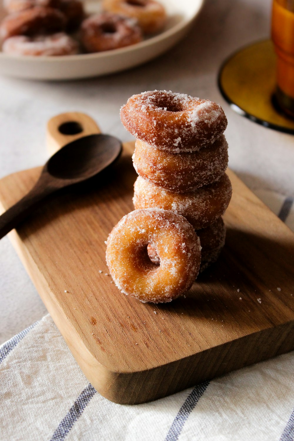 a pile of doughnuts sitting on top of a wooden cutting board