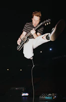 A student excitedly strumming an electric guitar during a fun, interactive lesson.