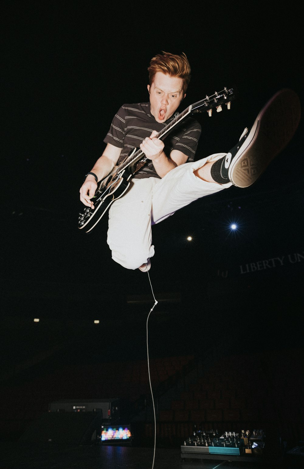 a man jumping in the air with a guitar