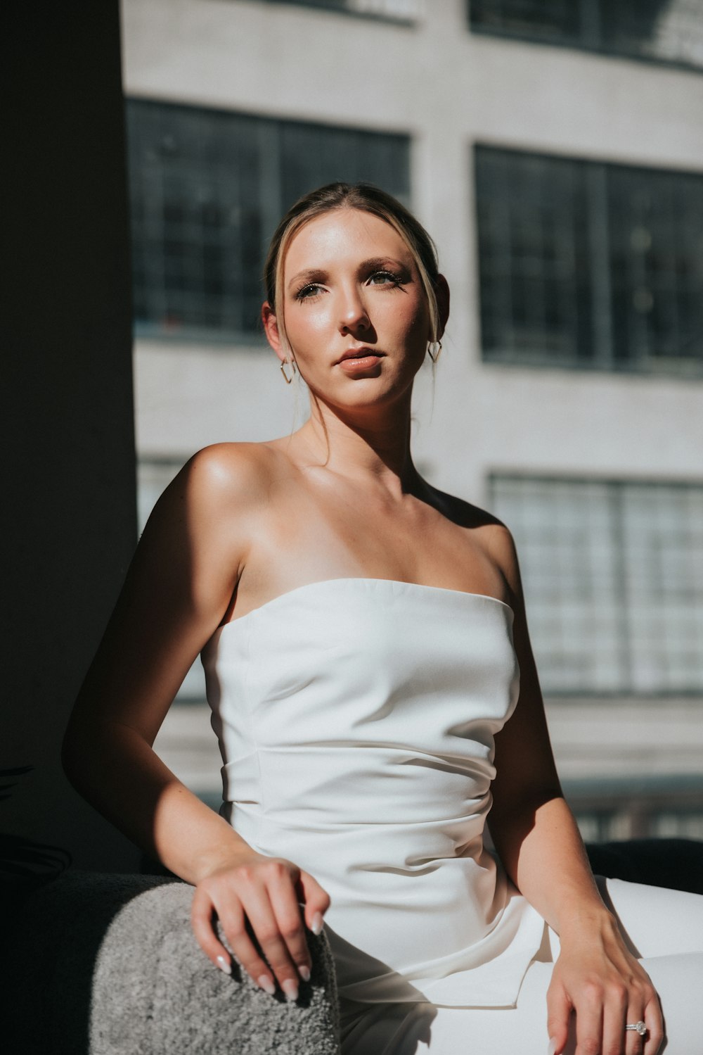 a woman in a white dress sitting on a couch