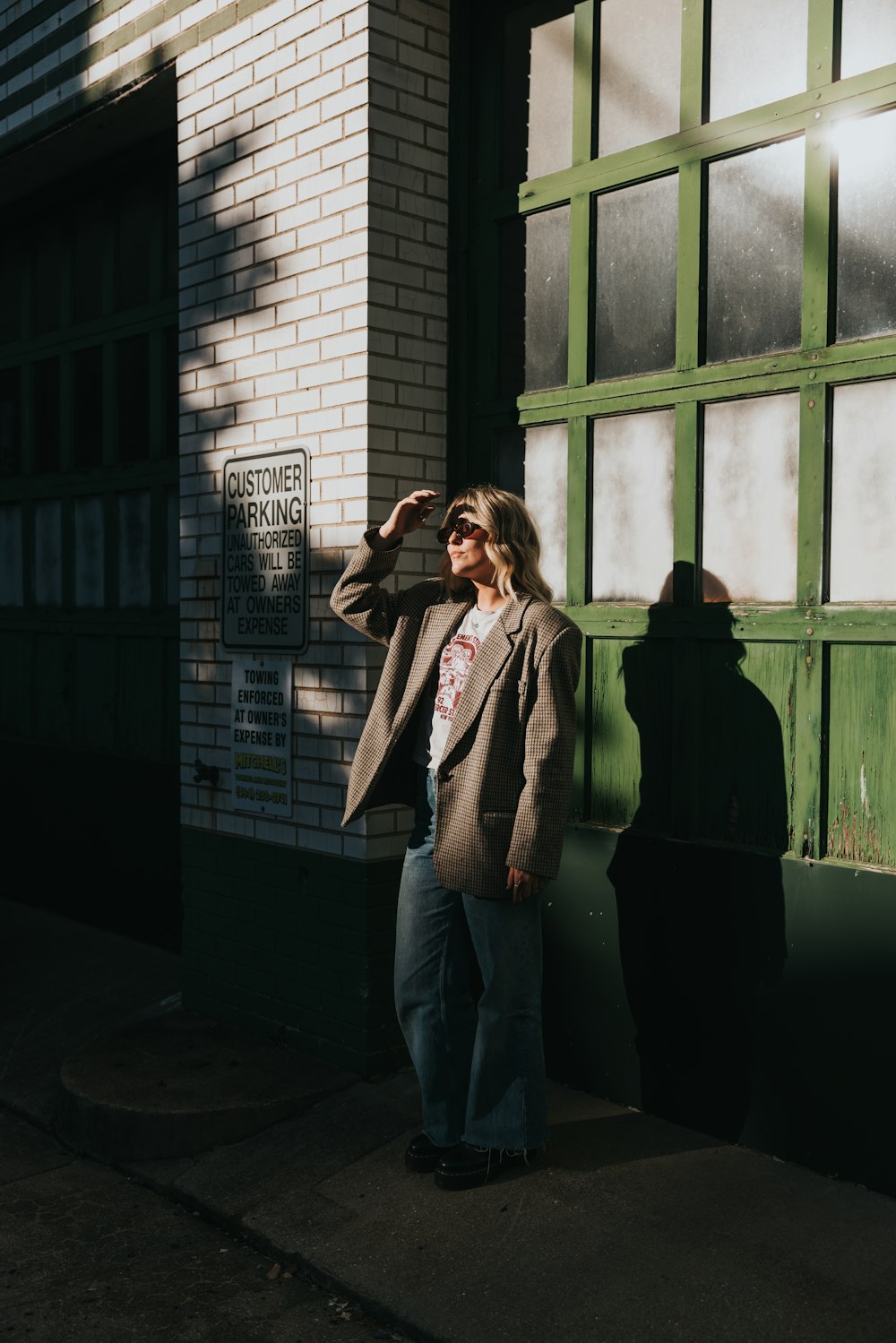 a woman standing in front of a building talking on a cell phone