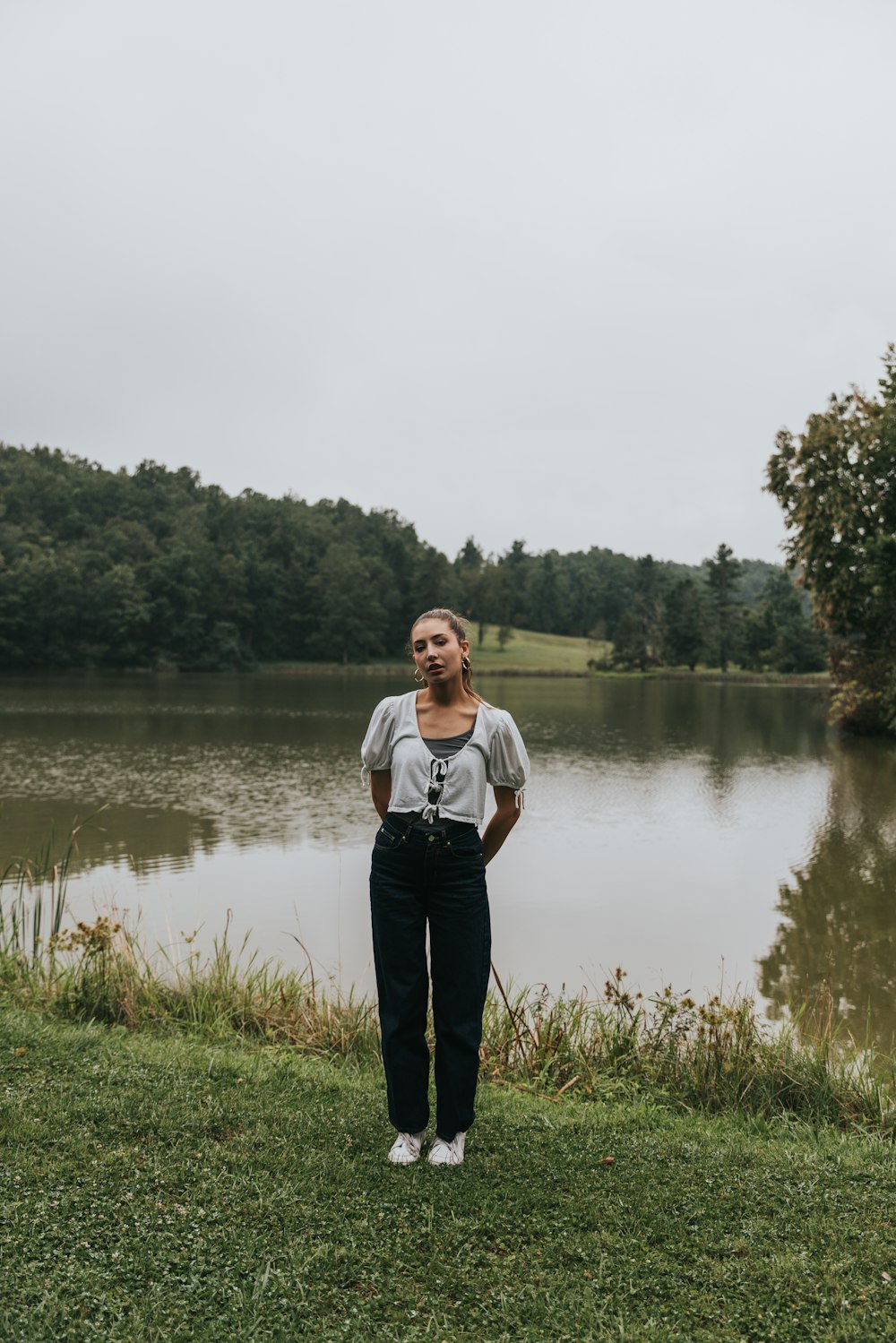 una donna in piedi di fronte a un lago