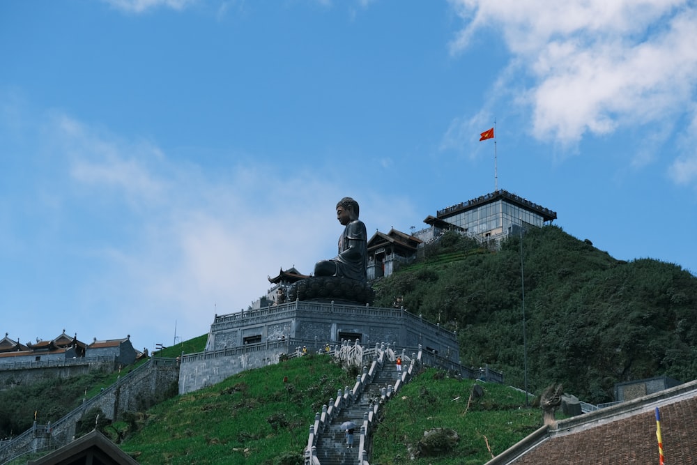 a statue of a man sitting on top of a hill