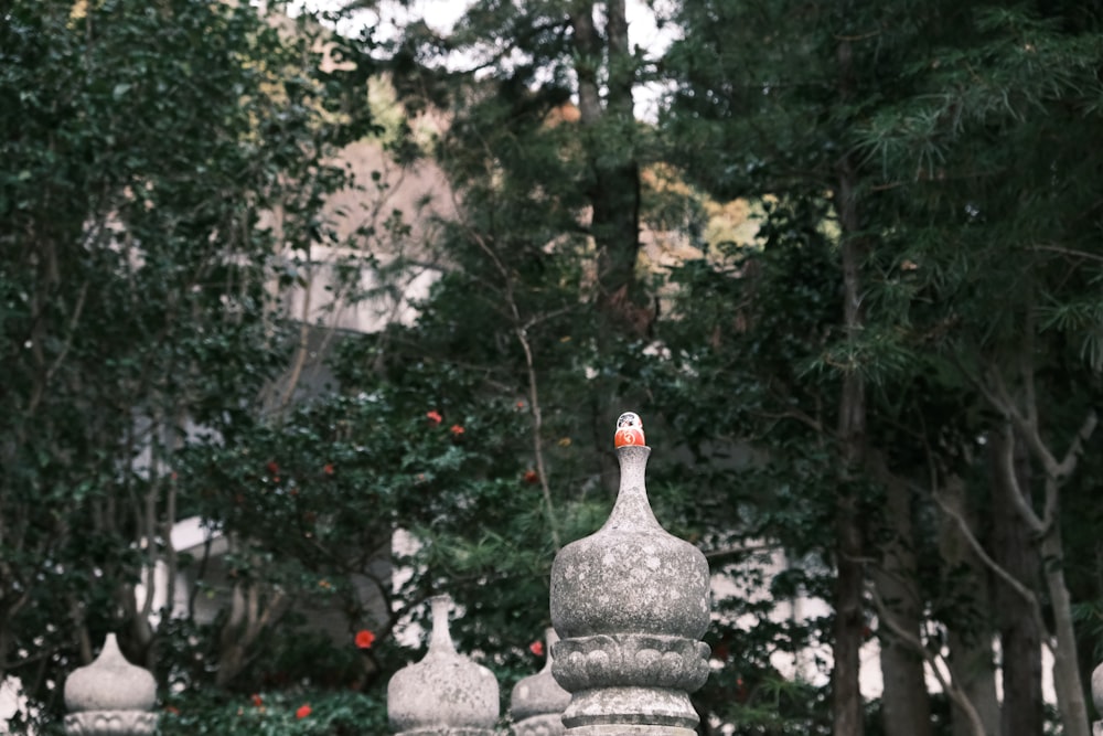 a group of white statues sitting next to a lush green forest