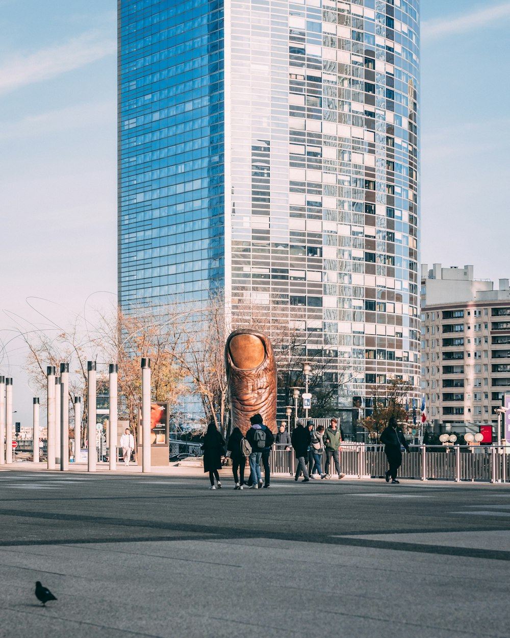 a group of people walking down a street next to tall buildings